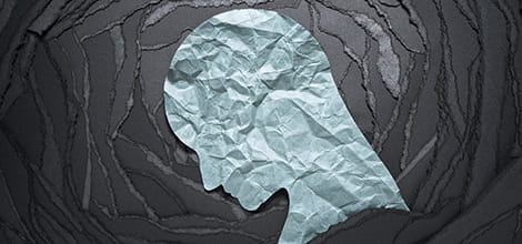 Illustration of a silhouetted head made of crumpled white paper, against a dark background.